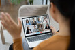 © NAMPIX - A woman sits at a desk with a laptop open, displaying a video conference meeting with her partnership.