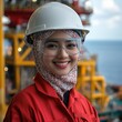 © Tadeusz - Cheerful female engineer in safety gear smiling on an offshore rig.