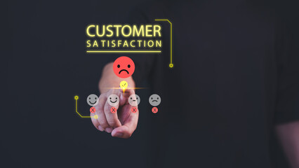 Fototapete - A hand selects a sad face on a customer satisfaction scale, indicating negative feedback. Bright text reads 