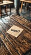 © Barosanu - A solitary note with 'WHEN?' inscribed on it is placed on a rustic wooden table top, invoking a sense of exploration and a quest for answers in viewers.