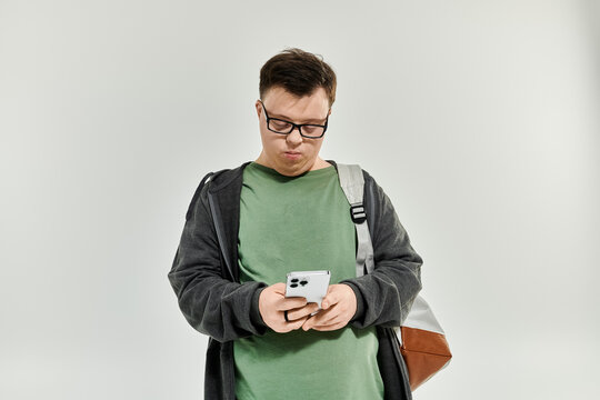 A man with Down syndrome enjoys texting while standing at home.