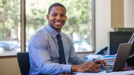 Poster - A man wearing a blue shirt and a tie is sitting at a desk with a laptop