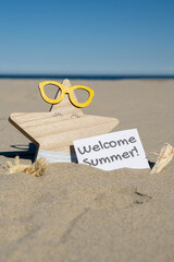 WELCOME SUMMER text on paper greeting card on background of funny starfish in glasses summer vacation decor. Sandy beach sun coast. Holiday concept postcard. Getting away Travel