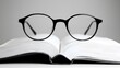 © Narit - Stylish glasses resting on an open book