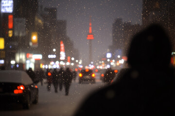 A blurry image of a city street at night with snow falling