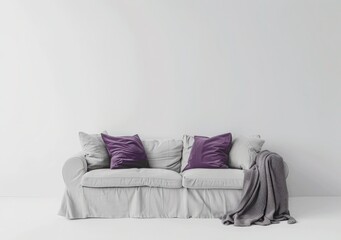 A white sofa with two purple pillows and a gray blanket in front of a white wall