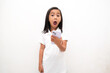 © vincent27 - Young lady looks at phone screen in front of eyes in surprise. Girl with headphones opens mouth shocked by information in gadget looking at picture