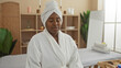 © Krakenimages.com - Young woman relaxing in a spa wearing a bathrobe with a towel over her head in a serene, indoor wellness center