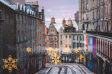 Victoria Street in Edinburgh adorned with festive Christmas lights and a fresh snowfall, capturing the charm of Scotland’s winter season in the heart of the old town.