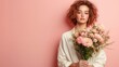 © JoxyAimages - A stylish woman with red hair and a white shirt holds a detailed bouquet of flowers against a pastel pink background, symbolizing freshness and modern elegance.