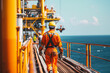 © ADDICTIVE STOCK CORE - Oil rig worker in safety gear walking on platform. Generative AI image