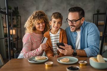 family of 3 have online shopping on mobile phone with credit card