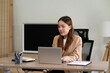 © sabthai - Young business woman using computer at desk in marketing