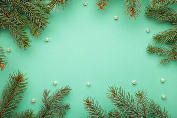 christmas minimal concept - christmas composition with fir branch and white bauble on mint backgroun
