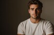 © Suriyo - A handsome man in a plain white T-shirt is bathed in vibrant studio lighting, with a clean gray background.