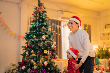 Joyful moments are shared as man and child celebrate Christmas together, surrounded by beautifully decorated tree adorned with ornaments and lights