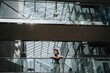 © Maskot - Low angle view of businesswoman standing by glass railing