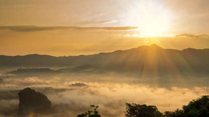 Wall Mural - Sunset mountain range beautiful landscape mist foggy sunrise beam. Golden sky Mountain landscape foggy windy mountain. Amazing Landscape cloud sky on sunrise. Countryside gold sunlight heaven scene