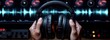 © Iurii - Hands holding headphones in a sound studio with audio waveforms displayed behind