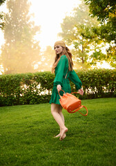 happy girl model in a green dress in the park. Fashion outdoor shooting.