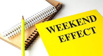 Poster - Weekend effect concept with text on a yellow notebook, a pencil, and other spiral notebooks,
