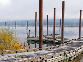 Dock on a river with a woman looking to the side.