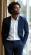 © imagineRbc - Dressed in a sleek navy suit, the young man leans casually against the window, contemplating his surroundings. The natural light enhances the sophisticated atmosphere