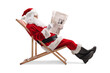 © Ljupco Smokovski - Santa claus reading a newspaper and sitting on a deckchair