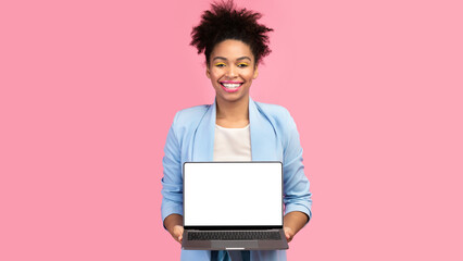 Poster - Useful Website. Cheerful afro girl holding laptop computer, showing blank screen over pink studio wall, mock up