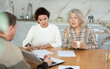 © JackF - Two female family members trying to reach agreement with man agent sitting opposite to them in the kitchen
