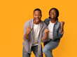 © Prostock-studio - Big Win. Happy Excited Black Couple Celebrating Success With Raised Fists, Cheerful African American Man And Woman Exclaiming With Joy While Standing Isolated Over Yellow Background, Copy Space