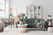 © Pixel-Shot - Modern minimalist living room interior design with gray sofa, woven furniture, and green plants for home decor