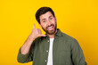 © deagreez - Portrait of nice young man show call me symbol wear khaki shirt isolated on yellow color background