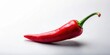 © Theerawat - A single vibrant red chili pepper, its smooth skin gleaming, rests on a plain white surface, the green stem curled upwards, creating a dynamic composition.
