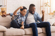 © Prostock-studio - Family Cheering. Afro Dad And Son Emotionally Supporting Their Favorite Team, Watching Sports On Tv At Home Together, Free Space