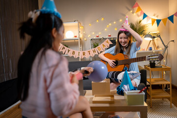 Two Asian women in room with Ciematic lighting celebrate important events such birthdays Christmas