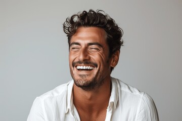 handsome young man laughing wearing white shirt isolated on white background professional studio portrait closeup smiling perfect teeth for advertisement web design