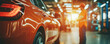 © BOW_NAPASORN - A man in an orange safety vest stands in front of a shiny orange car. The car is parked in a garage, and the man is inspecting it. Concept of professionalism and attention to detail