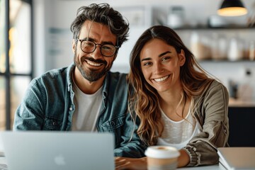 Young business people smiling and working together on laptop in office meeting