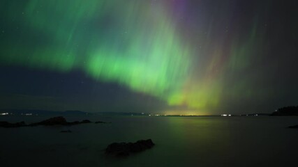 Wall Mural - Colorful Northern Lights dancing above the ocean in Vancouver Island, Canada. Timelapse. 