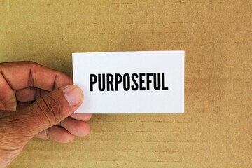 hand and white paper with the word purposeful. goal concept. actions, behaviors, or decisions that are driven by a clear sense of purpose, intention, or goal