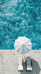 A white umbrella and two sunbeds by the swimming pool, bird's eye view of the close-up shot of blue water