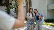 © bongkarn - Two friendly Asian students are saying goodbye to their friend while walking in their college.