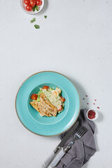 Wall Mural - Classic Caesar Salad with Chicken Fillet on Minimalistic Blue Plate - Modern Food Photography