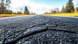 © Nattapol - Close up of weathered asphalt texture with minor cracks, showcasing road surface and surrounding nature. image evokes sense of travel and exploration