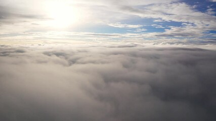 Wall Mural - aerial view over cloudscape from airplane flying in sunset sky time with thick fog above the beautiful ocean of clouds in sundown.Flying in soft clouds aerial perspective view over clouds background