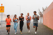 © PintoArt - Athletes running together on foggy city street