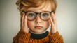 © Natalia S. - Little boy with glasses for vision correction looks at the camera with a sad look. Consultation with an ophthalmologist. Deterioration of vision at a young age in children, myopia and hyperopia