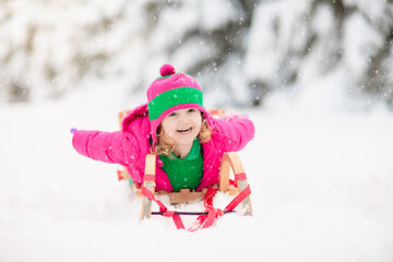 Wall Mural - Child playing with snow in winter. Kids outdoors.