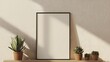 © Liisa - A vertical blank poster frame is placed on top of the console table, with plants in wooden pots beside it.